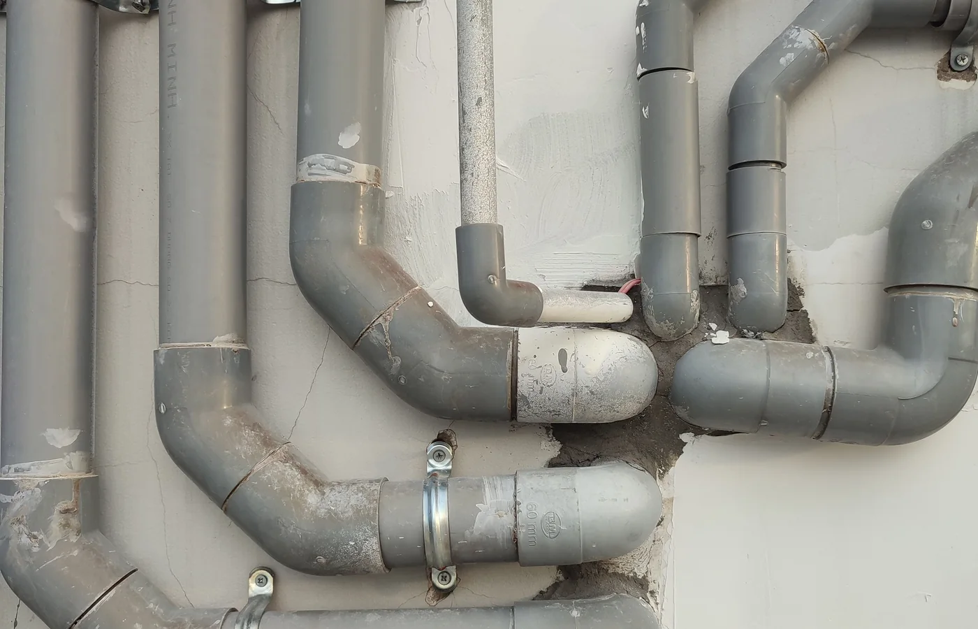 Waste pipework running along a basement wall after clearing
