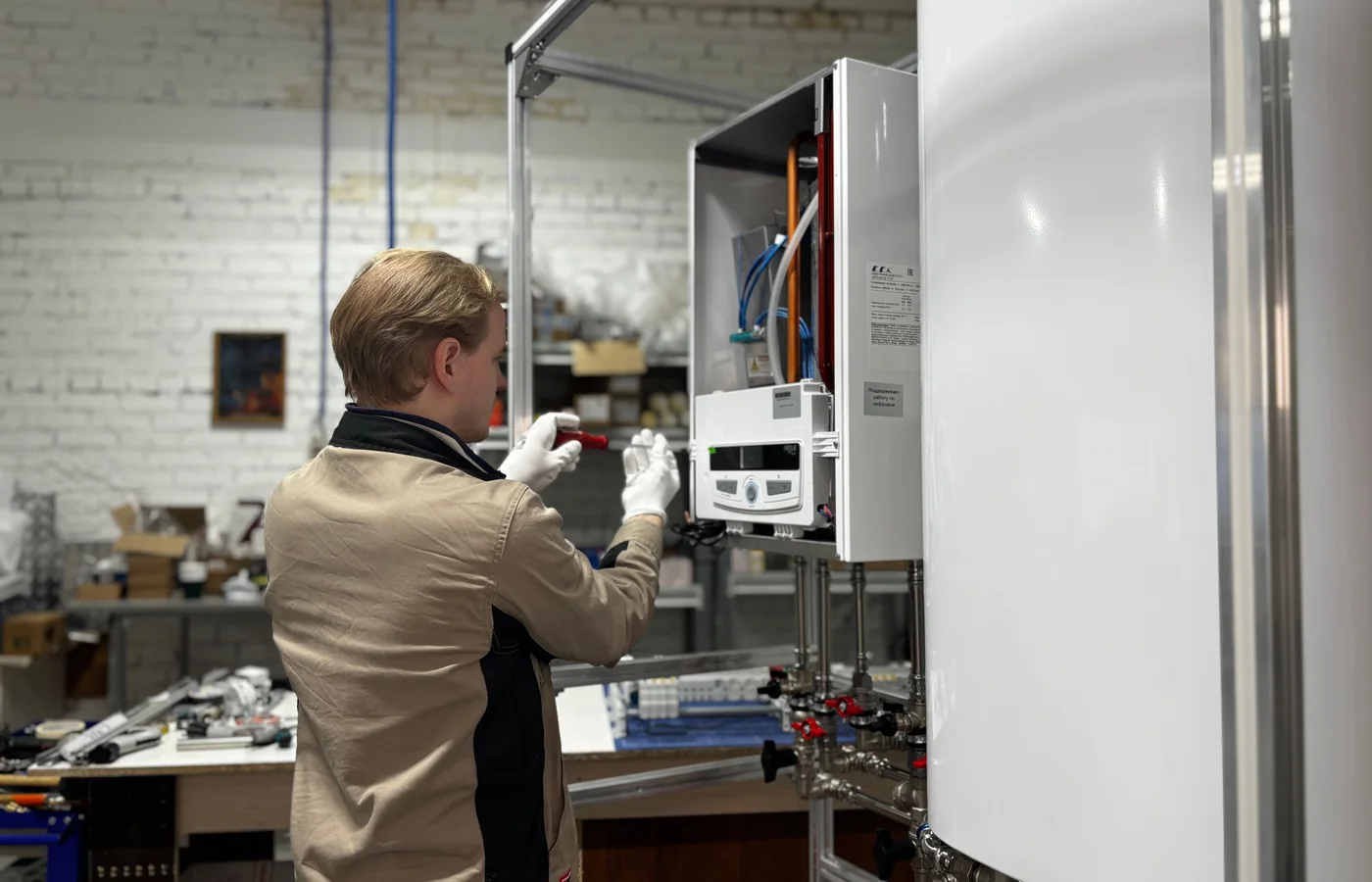 Technician servicing the internals of a wall-mounted combi boiler