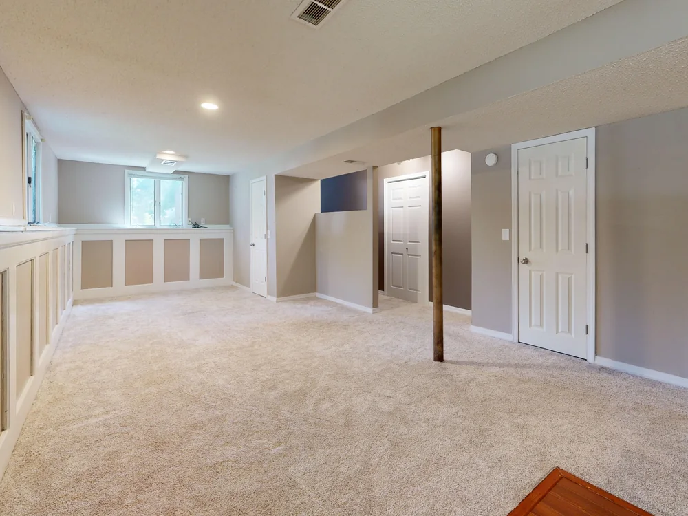 Finished dry basement with carpeted floor and painted walls